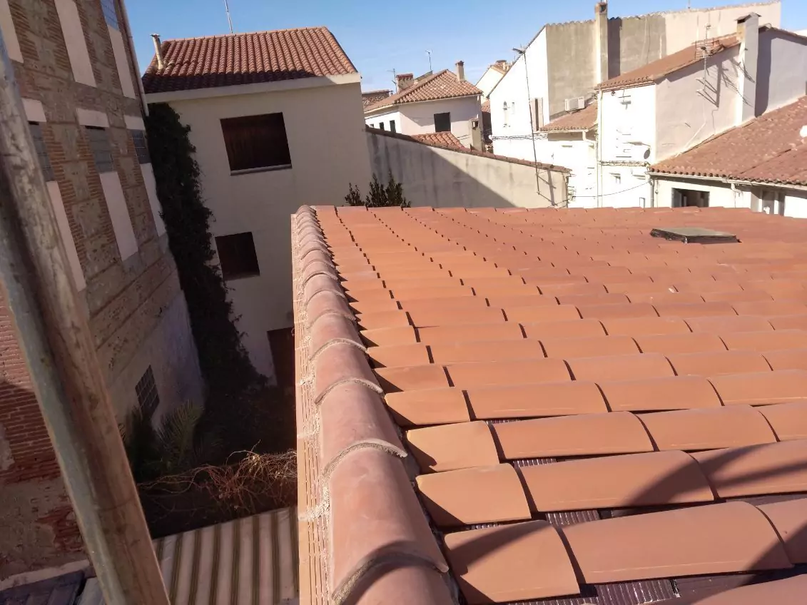 Un ouvrier en train de travailler sur une charpente de maison